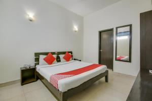 a bedroom with a large bed with red pillows at Hotel O Dream View in Gurgaon