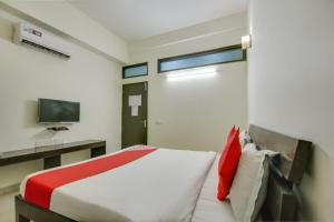 a bedroom with a bed with a red and white bedspread at Hotel O Dream View in Gurgaon