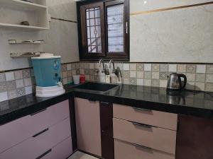 a kitchen with a sink and a counter top at Keshu Home Stay Hampi in Hospet