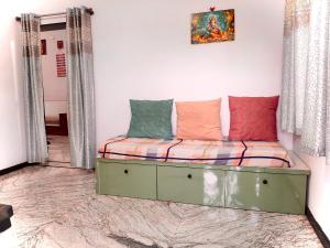 a couch with pillows on it in a room at Keshu Home Stay Hampi in Hospet