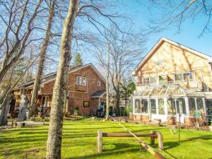 a large house with a conservatory in the yard at Estivant Club in Tsumagoi