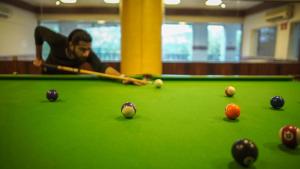 a man playing a game of snooker on a pool table at ORYN-Celebrity Resort, Shamirpet, Hyderabad, Secunderabad, in Shamirpet