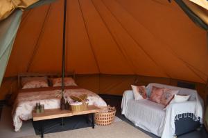 two beds and a couch in a tent at Artemilland B&B in Burzanella