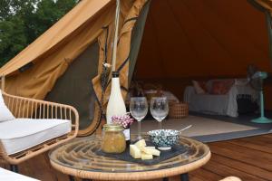 a table with two glasses and cheese and a tent at Artemilland B&B in Burzanella