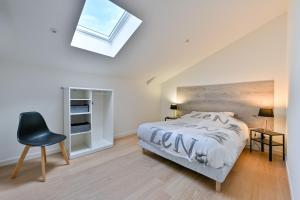 a bedroom with a bed and a chair and a skylight at Laurière - Wifi - Parking - Pet friendly in Port-Saint-Père +10 photos