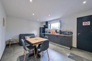a kitchen and dining room with a table and chairs at Laurière - Wifi - Parking - Pet friendly in Port-Saint-Père