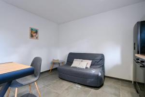 a living room with a leather couch and a table at Laurière - Wifi - Parking - Pet friendly in Port-Saint-Père