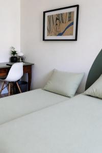 a bedroom with a bed and a desk and a picture at Le Nid Didier in Saint-Didier-en-Velay
