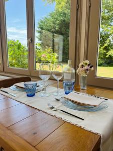 a table with wine glasses and plates on a table at Maison Nolette - Chambres & Table d'hôtes in Noyelles-sur-Mer