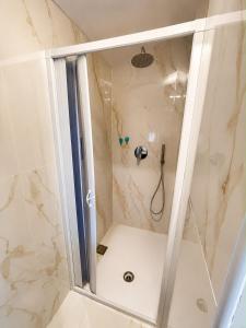 a shower with a glass door in a bathroom at Domus Tarquinia in Tarquinia