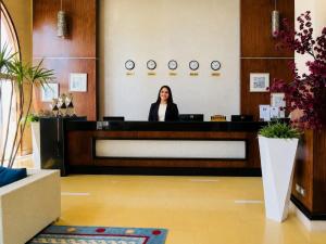 a woman sitting at a reception desk in a lobby at Porto Matrouh Hotel in Marsa Matruh +50 photos