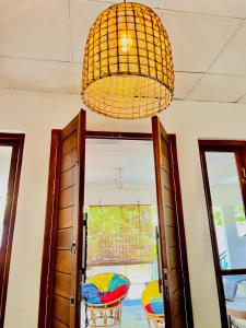 a chandelier hanging over a room with a window at Kumudu Holiday Home in Hiriketiya