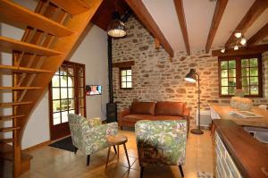 a living room with a couch and a table and chairs at Les frênes in Cussac