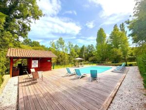 a wooden deck with a pool and a gazebo at Les frênes in Cussac