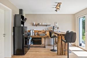a kitchen with a wooden table and a black refrigerator at Auszeit Helsa in Helsa
