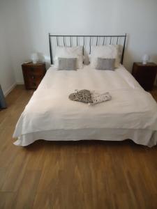 a bed with white sheets and pillows on it at Casa da Paz in Odeleite