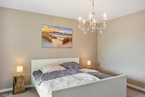a bedroom with a bed and a chandelier at Auszeit Helsa in Helsa