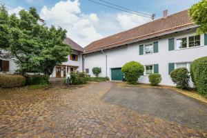a cobblestone driveway in front of a white house at Apartment Gardenview in Kinsau