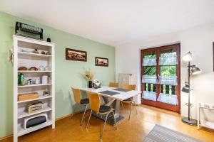 a dining room with a white table and chairs at Apartment Gardenview in Kinsau