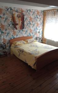 a bed in a bedroom with a wall at Écrin de tranquillité in Rosières-en-Santerre