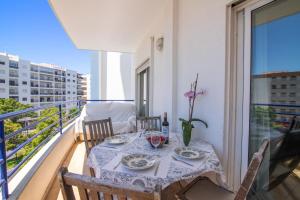 a table on a balcony with a table and chairs at Rei Apartment in Quarteira