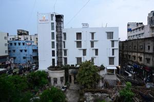 a white building in the middle of a city at Trevon Hotel Gujrat Centrale, Ranchi in Rānchī