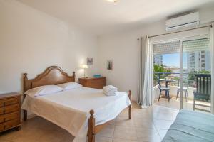 a bedroom with a bed and a balcony at Rei Apartment in Quarteira