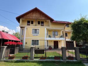 a yellow house with a fence in front of it at Casa Dany in Vatra Dornei +16 photos