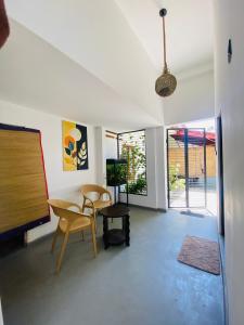 a living room with a table and chairs and a tv at Greenbliss Hiriketiya in Dickwella