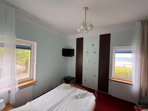 a bedroom with a bed and two windows at Zajazd Dajana in Ustka