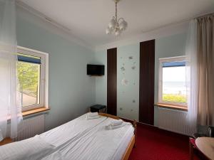 a bedroom with a large bed and two windows at Zajazd Dajana in Ustka