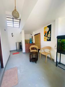 a living room with a tv and a table and chairs at Greenbliss Hiriketiya in Dickwella
