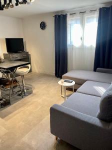 a living room with a couch and a desk at Appartement piscine sans vis à vis in Caumont-sur-Durance