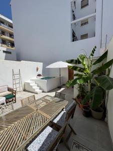 a patio with chairs and a table and an umbrella at Céntrico duplex con piscina in Jávea