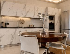 a kitchen with a wooden table and white appliances at ComeCasa No ZTL Alfieri Urban Stay in Asti