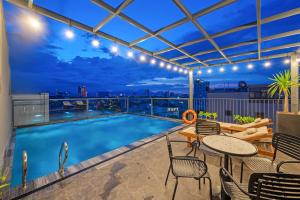 a patio with a pool and tables and chairs with a view at MAIA Boutique Hotel Da Nang in Danang