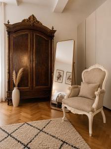 a room with a chair and a mirror at ComeCasa No ZTL Alfieri Urban Stay in Asti