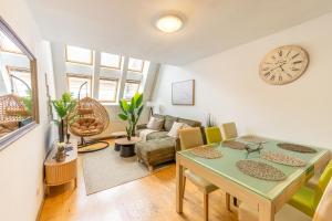 a living room with a table and chairs and a clock at Gellerico Apartments Wesselényi Street in Budapest