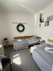 a bedroom with two beds and a mirror on the wall at Amur Vendégház in Gárdony