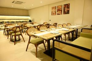 a dining room with tables and chairs in a restaurant at Trevon Hotel Gujrat Centrale, Ranchi in Rānchī