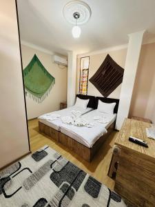 a bedroom with two beds and a table and a mirror at Mashhur in Bukhara