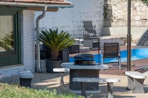 a grill sitting on a patio next to a pool at Döbrögi Wellness Vendégház in Nemesvita