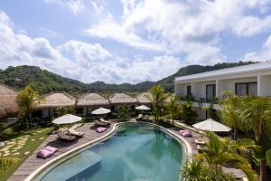 an image of a resort pool with chairs and umbrellas at Uryah Hotel Lombok in Selong Belanak