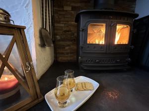 a table with two glasses of wine and a stove at Dunhallin Ard in Hallin