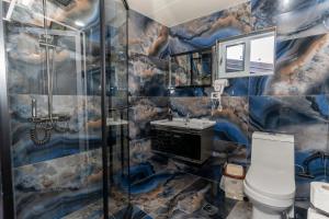 ein Badezimmer mit einem Bergmotiv an der Wand in der Unterkunft Hotel Platea in Shkodra + 72 Fotos