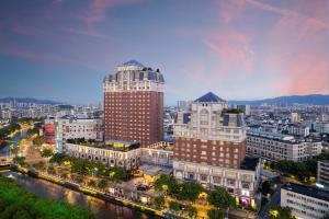 a city skyline with a tall building and a river at Grand Pacific Hotel Ningbo in Yuyao