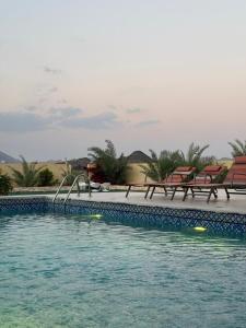 a swimming pool with two chairs and a slide at Moonlight Resort in Sinādil