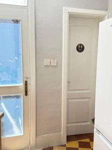 a white door with a clock on it next to a window at Arantza House in Sliema +17 photos