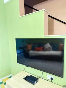 a large flat screen tv hanging on a wall at Arantza House in Sliema