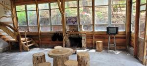a room with a fireplace and a tv and logs at Mộc Tín Farmstay in Lạc Dương